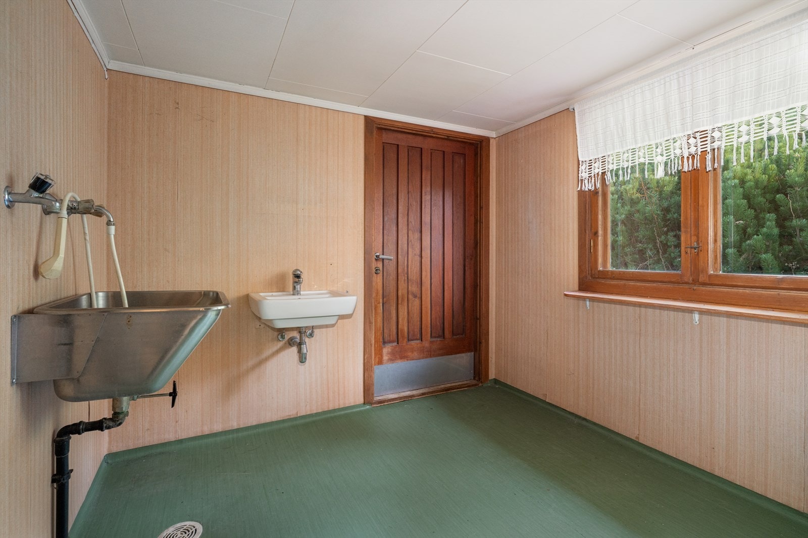 Vaskerom med egen utgang. Rommet er innredet med utslagsvask og servant på vegg. Galleribilde