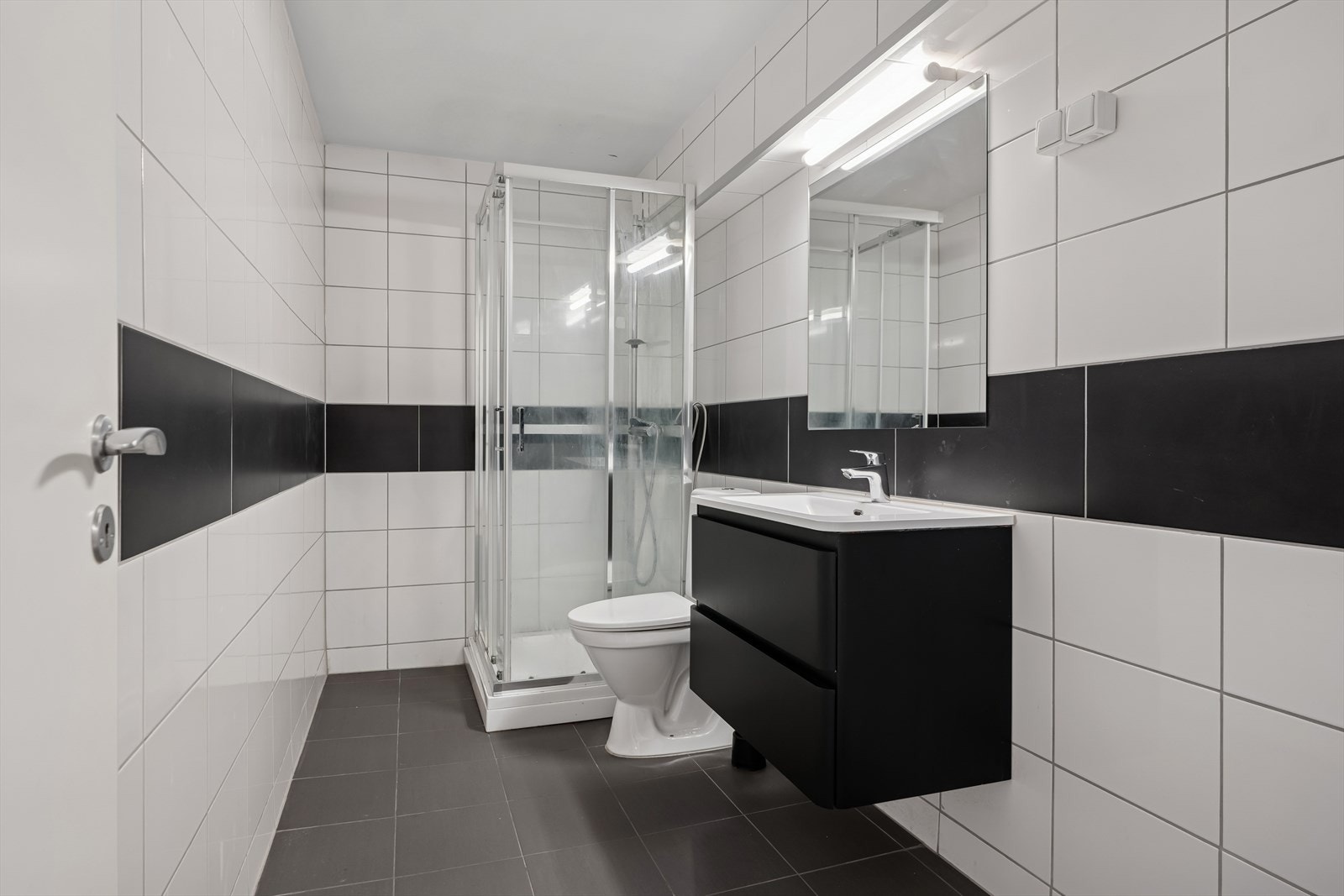 Rommet har baderomsinnredning med heldekkende servant og underskap med skuffer, frittstående toalett og dusjkabinett. Galleribilde