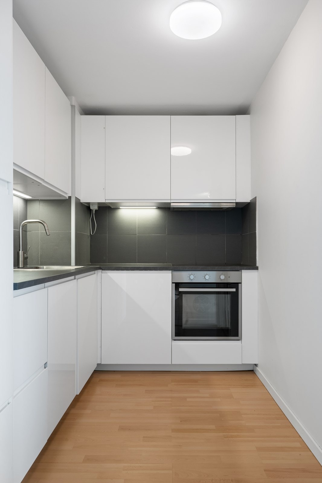 Innredningen har lyse slette fronter og laminerte benkeplater med nedfelt oppvaskkum i rustfritt stål, ett-greps vannkran. Det er lys montert under overskap. Integrerte hvitevarer som stekeovn, koketopp, oppvaskmaskin, kjøleskap m/frys. Galleribilde