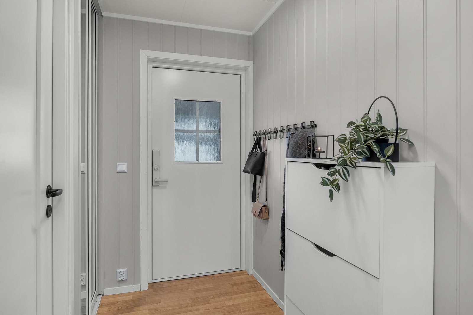 Gang med skyvedørsgarderobe som gir praktisk oppbevaring av ytterbekledning. Ytterdøren ble skiftet i 2024. Galleribilde
