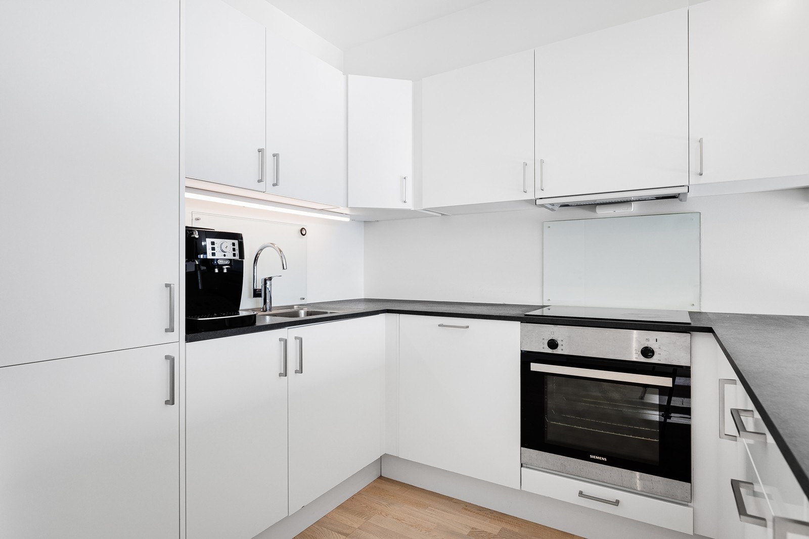 Sigdal kjøkken med hvite slette fronter og laminat benkeplate. Galleribilde