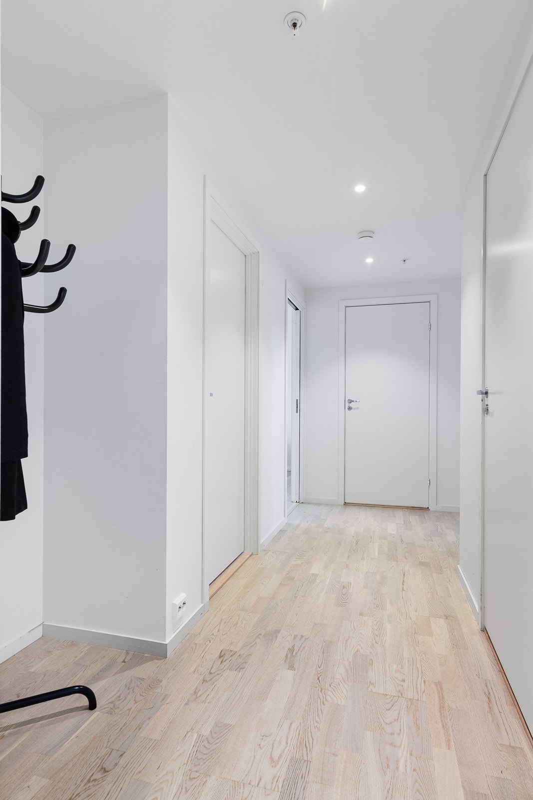 Entréen har lys parkettgulv og malte gipsvegger, med downlights som gir god belysning. Galleribilde
