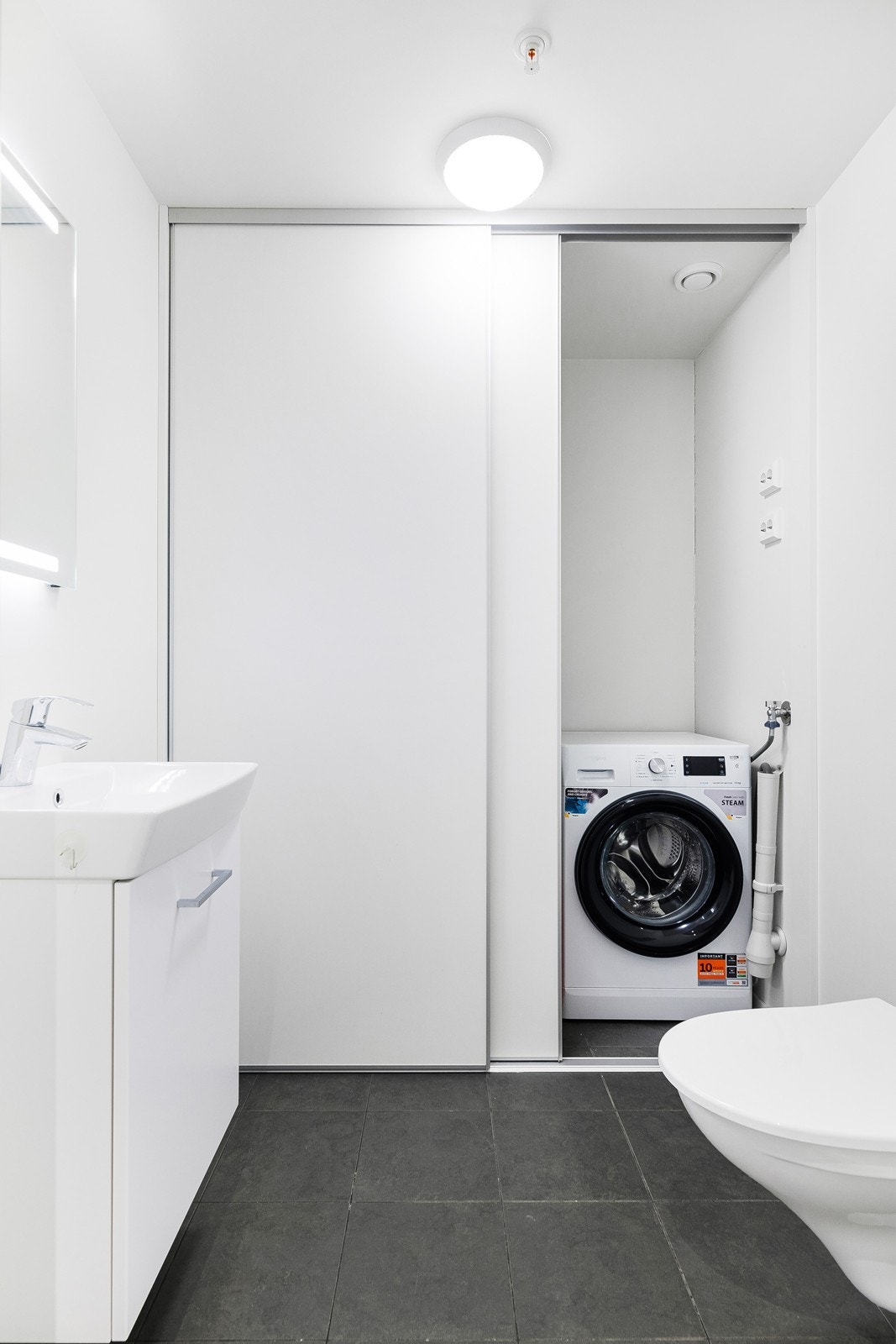 Plassering av vaskemaskin i eget rom gir praktisk vaskeløsning. Galleribilde