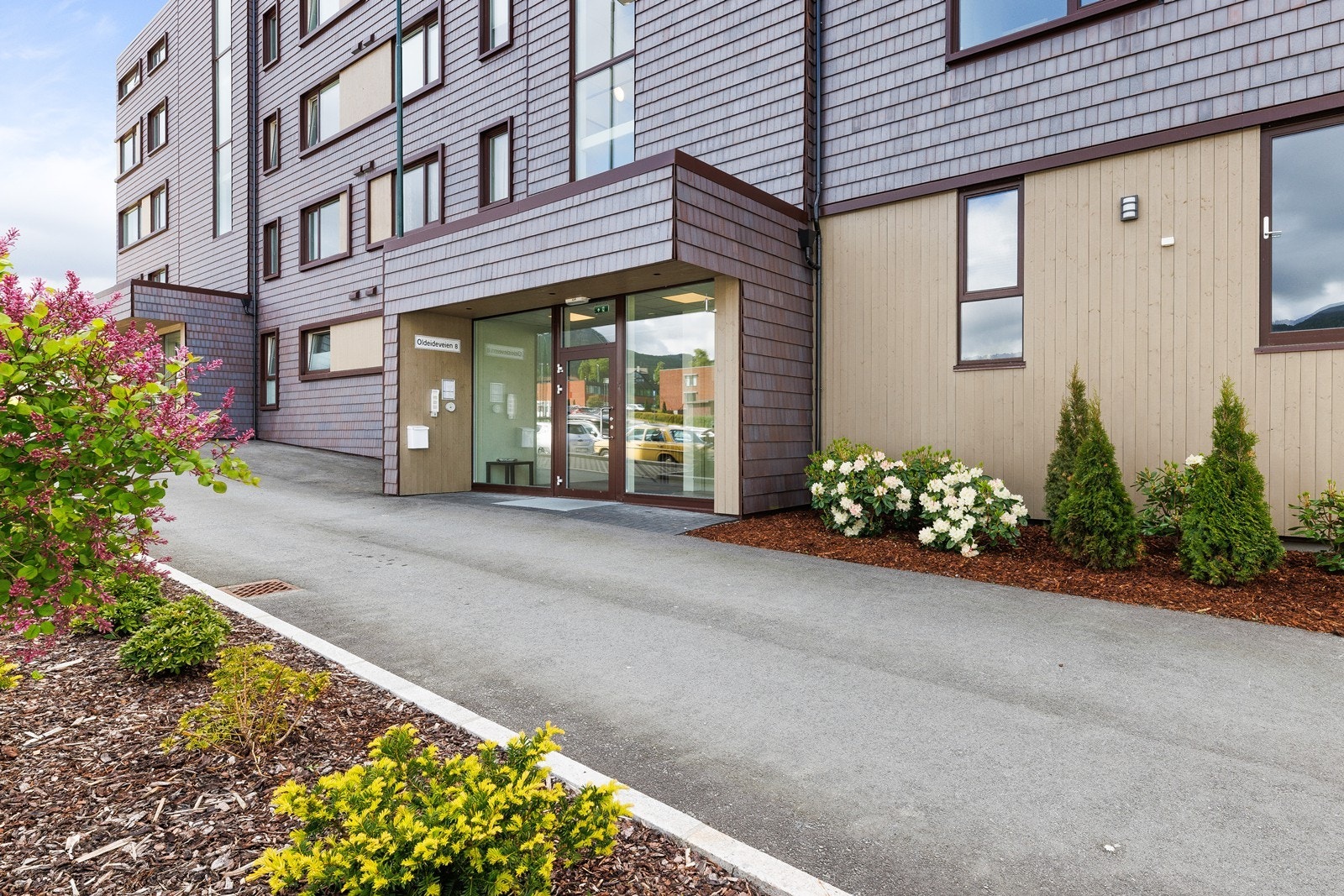 Inngangspartiet har en innbydende utforming med beplantning langs gangveien. Galleribilde