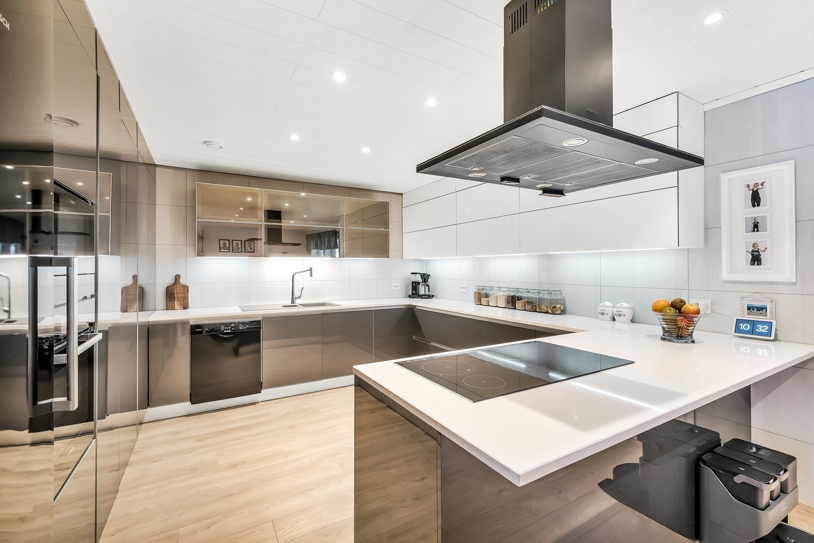 Italiensk kjøkkeninnredning med slette fronter og benkeplate i stein. Galleribilde