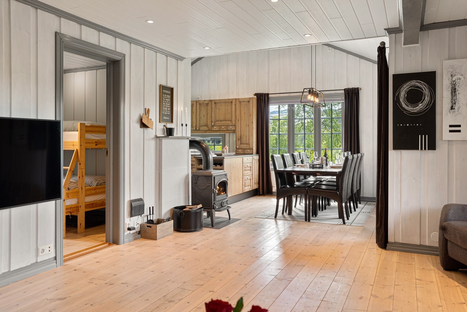 Fra spiseplass er det god oversikt over stuen og kjøkkensonen. Vedovn til kalde dager. Galleribilde