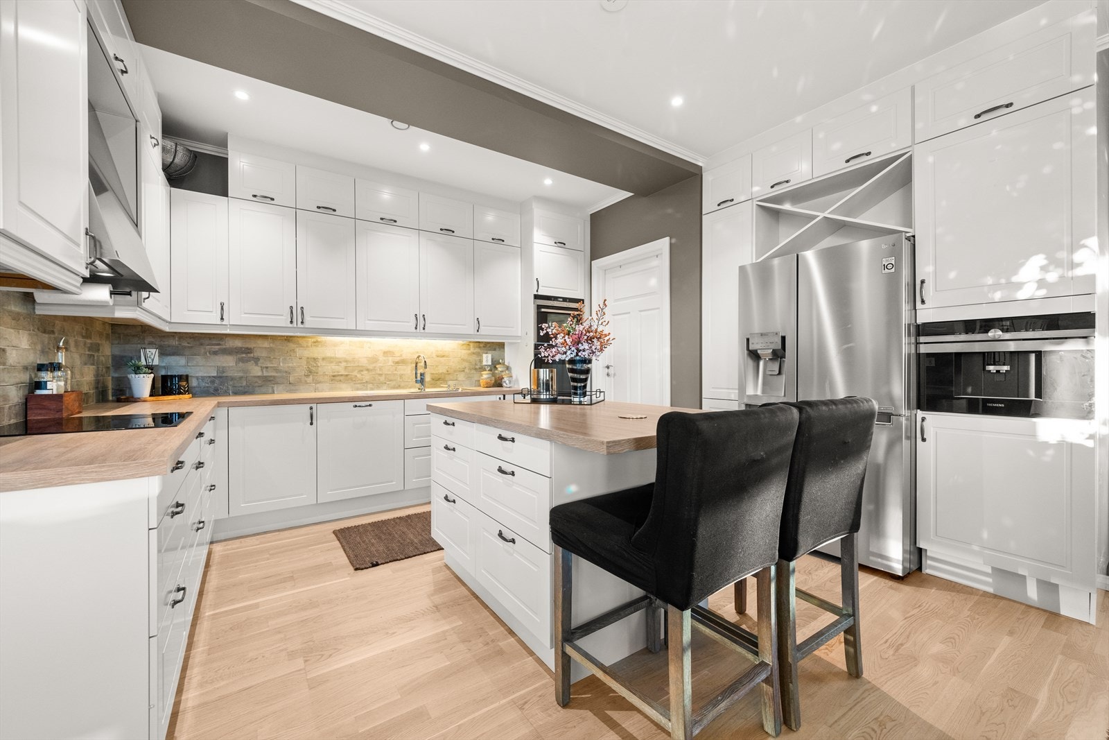 Stort kjøkken fra HTH med mye skapplass, frittstående øy og integrerte hvitevarer. Galleribilde