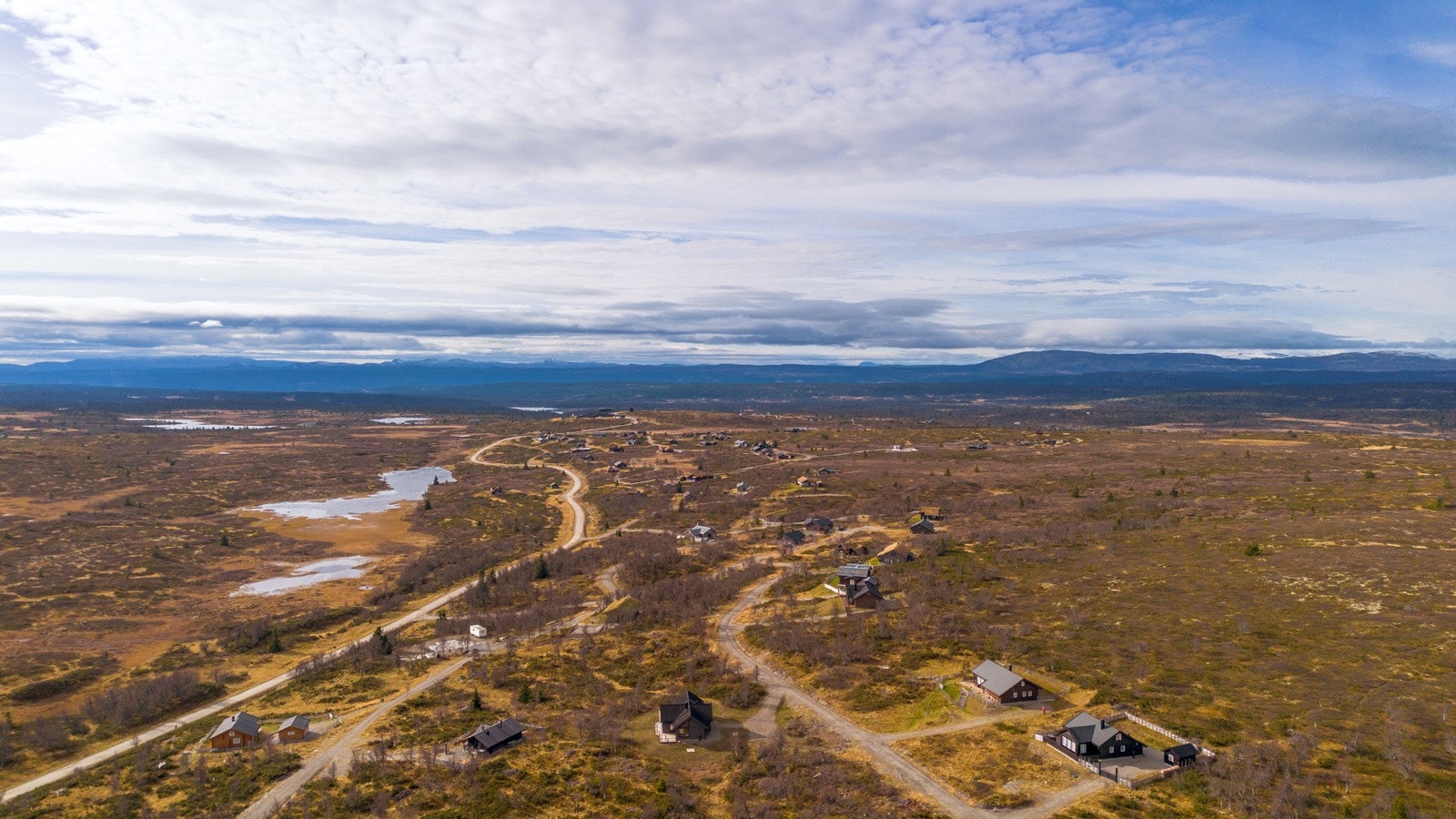 Dronebilde sett i retning leirskolen med tomten like bak Galleribilde