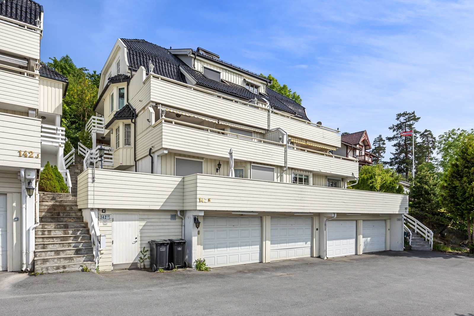 Bygget ligger i en rolig og trafikkstille blindvei, omgitt av frodige trær og beplantning som skaper idyll. Galleribilde