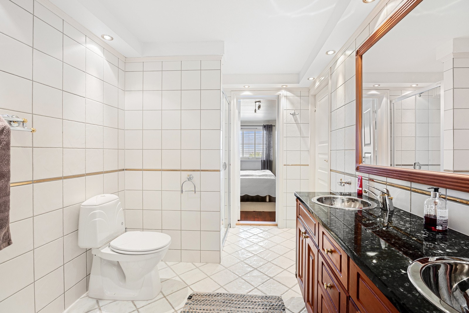 Badet har en romslig innredning med dobbelservant, god skapplass, toalett, speil og dusjnisje. Galleribilde