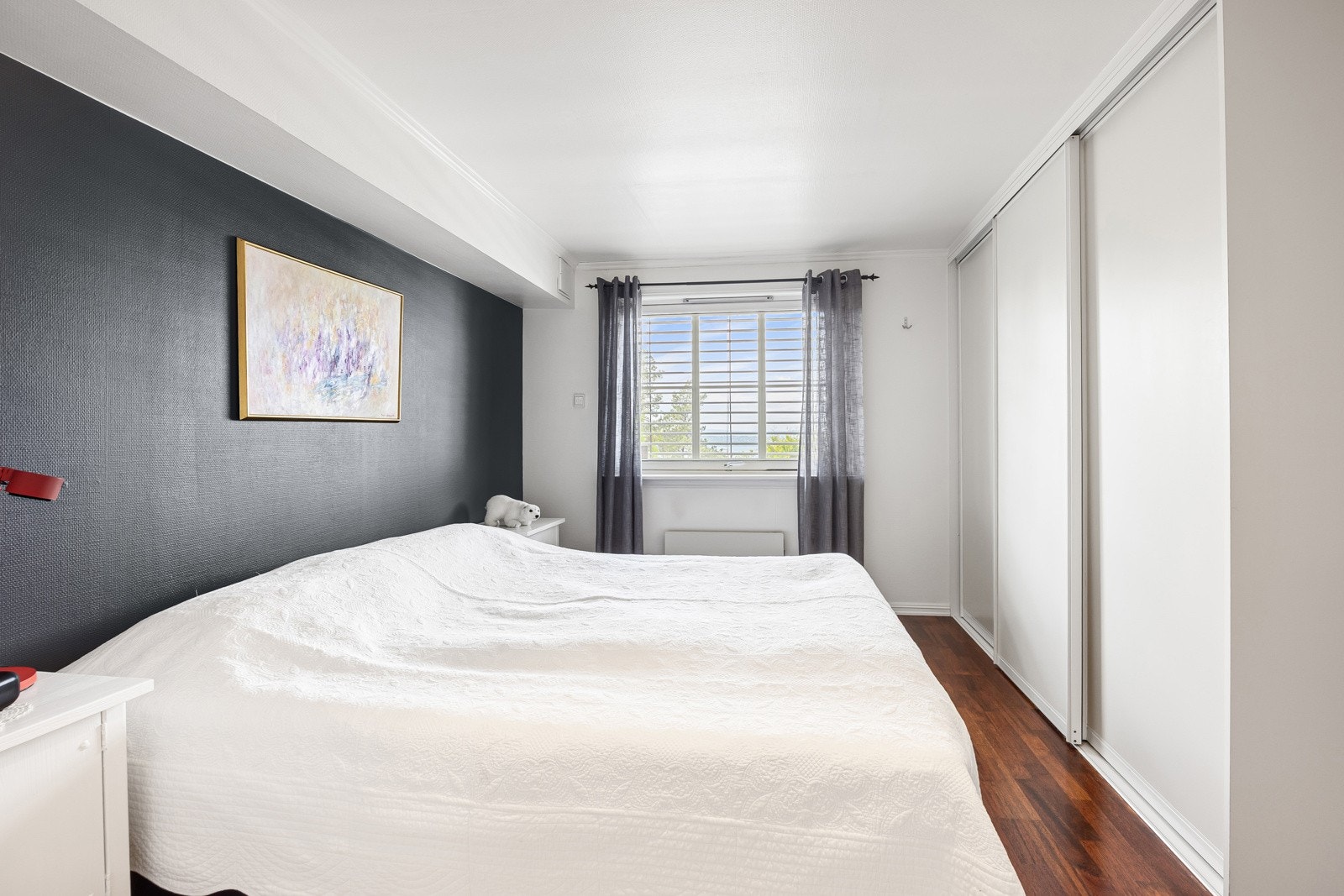 Den ene veggen er innredet med plassbygd skyvedørsgarderobe som gir godt med oppbevaringsplass. Galleribilde