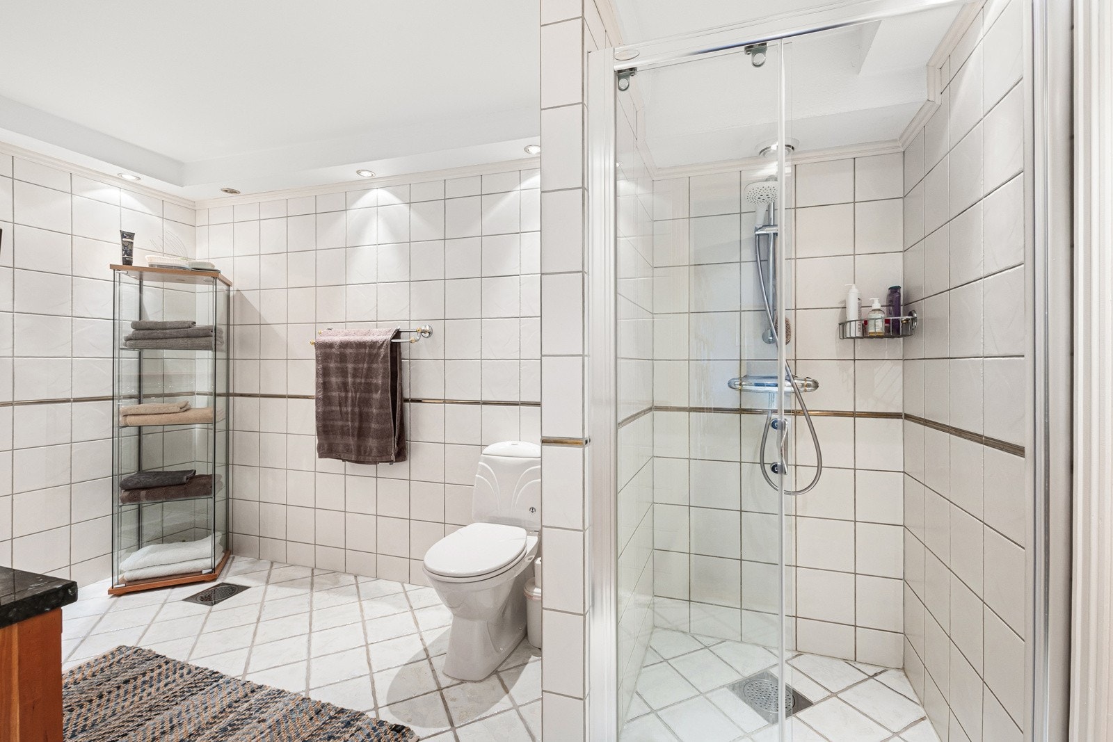 Rommet er helfliset med varmekabler i gulvet og foldbar glassdør i dusjnisjen. Galleribilde