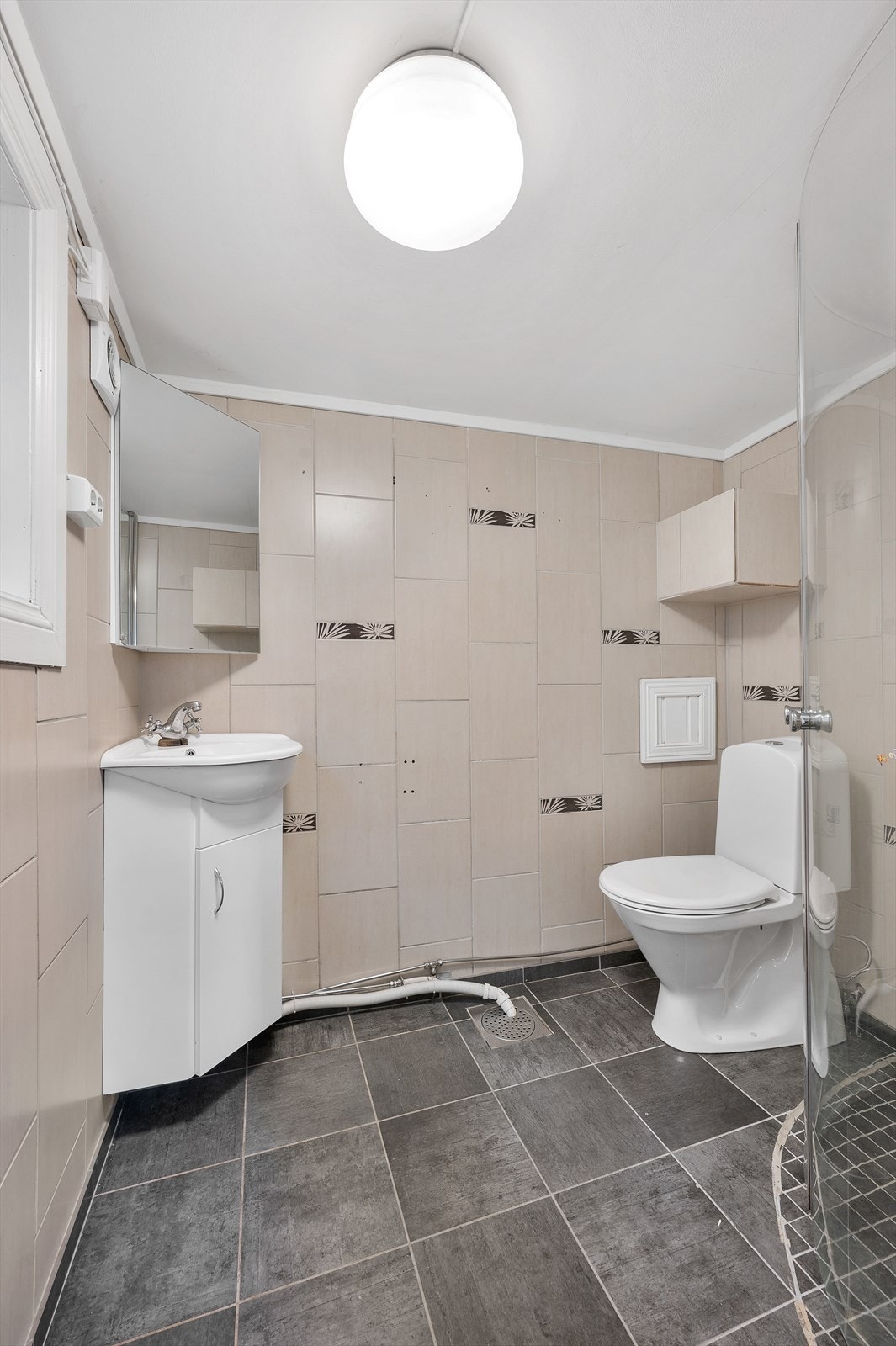 Bad med servant, toalett og dusjhjørne med glassvegger. Galleribilde