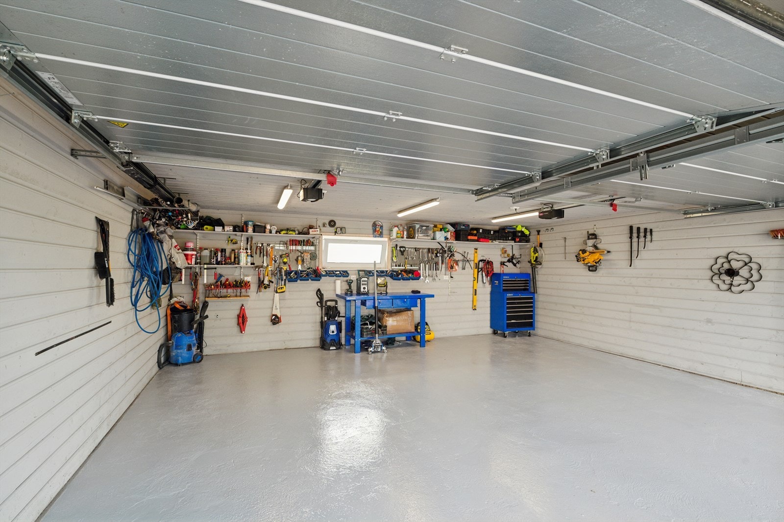 Romslig garasje med plass til to biler og god lagringsplass for redskap. Galleribilde