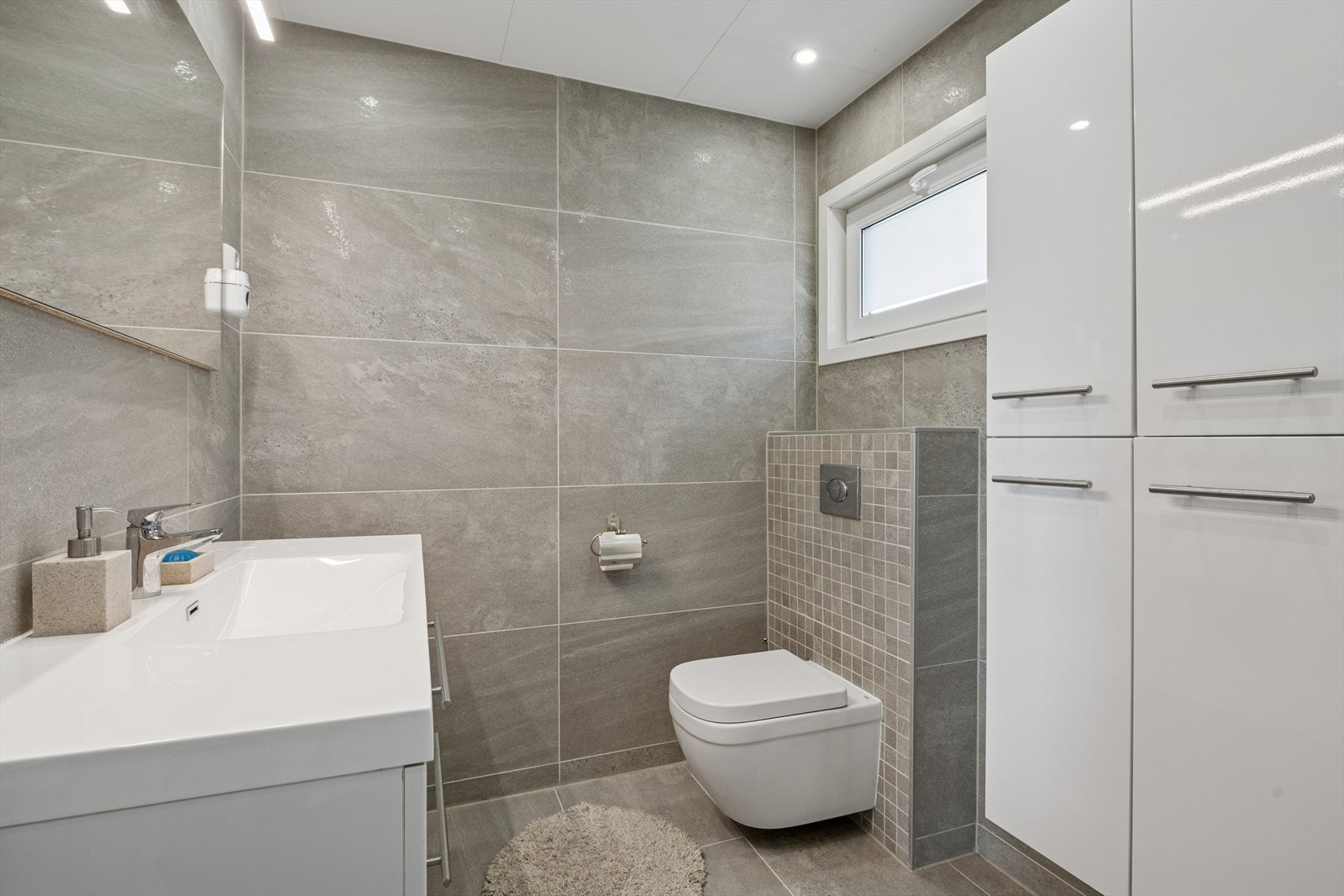 Rommet inneholder servantinnredning, håndkletørker, dusj med vegger og badekar. Galleribilde