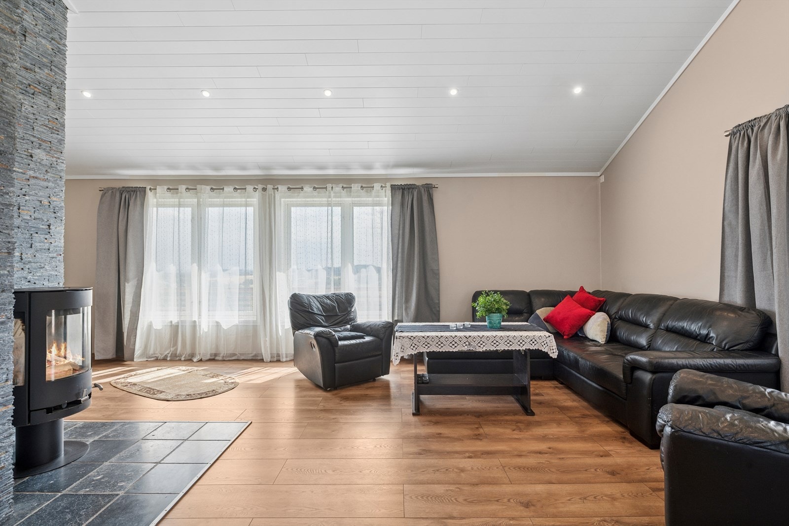 Stuen er innredet med hjørnesofa og sofastol, og har montert vedovn. Galleribilde