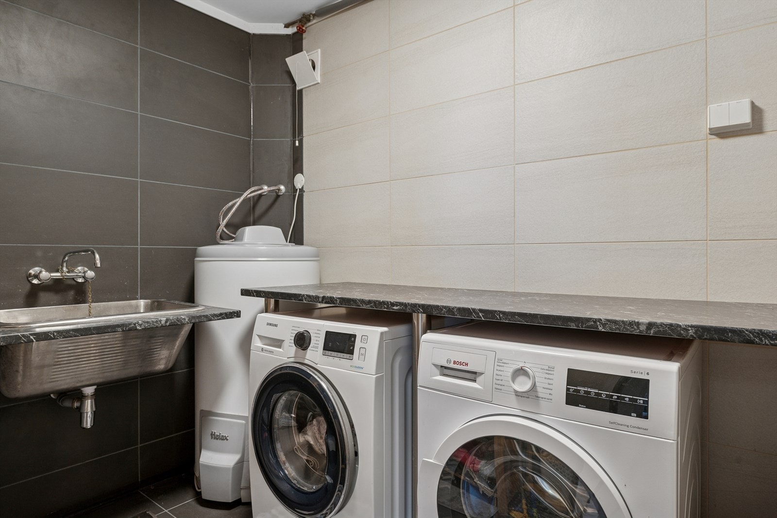 Vaskerom i underetasje fra 2019 med flislagte gulv av betong med varmekabler (tidligere bod). Galleribilde