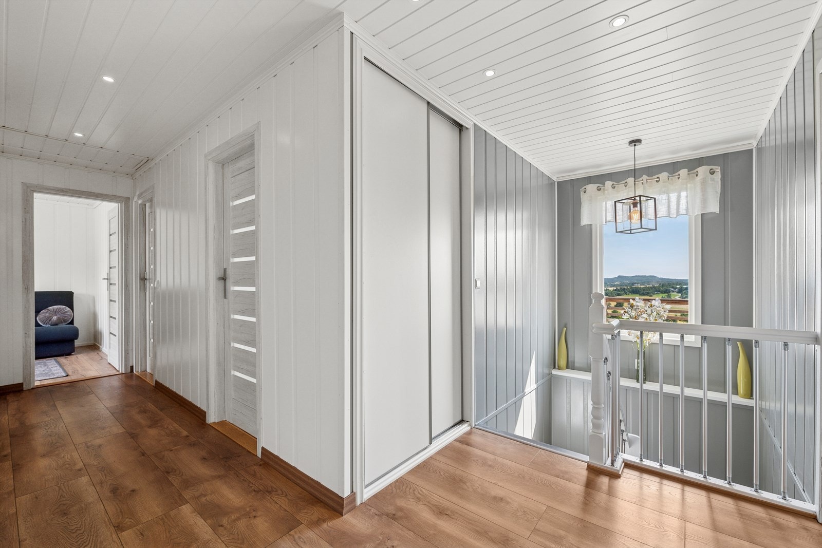 Lys og innbydende gang med downlights og innebygd garderobeskap med praktiske skyvedører. Galleribilde
