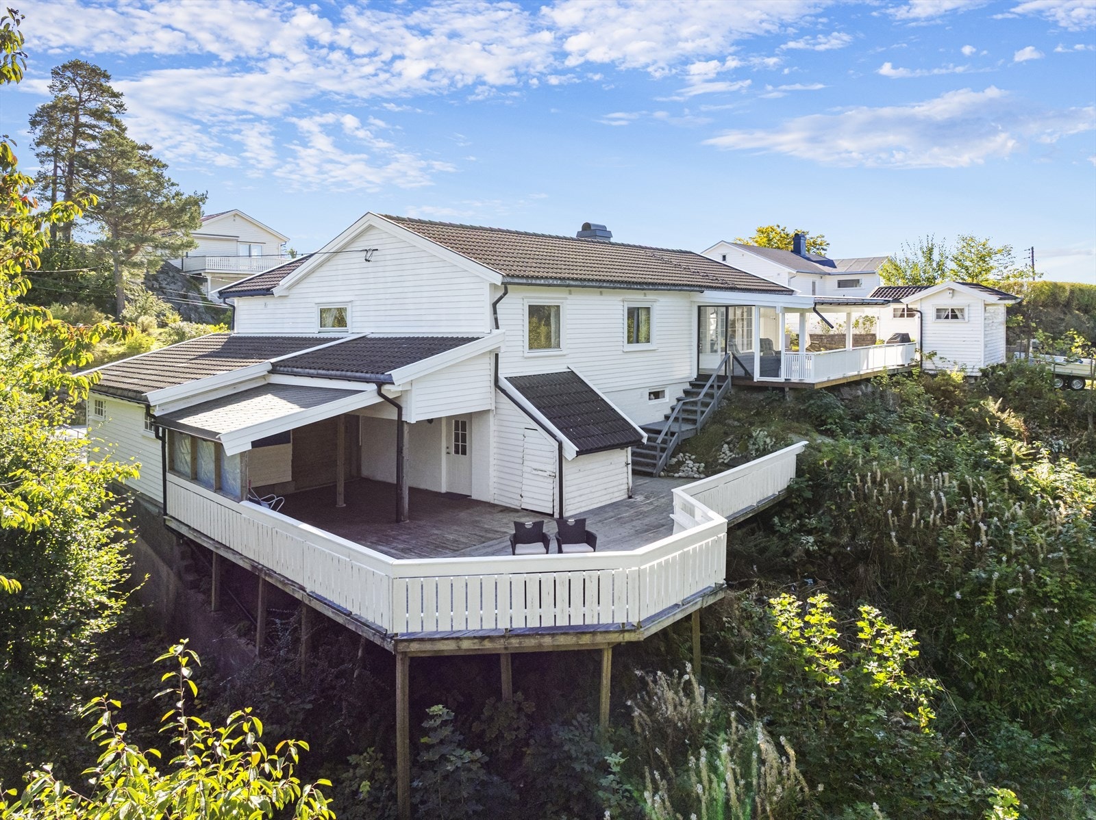 Mot vest er der stor terrasse, hvor man sitter skjermet i solen hele dagen. Her er også 2 praktiske hageboder. Videre har man direkte adgang til stor, vestvendt terrasse som vender mot friareal, og på tilsammen over 100 m2 fordelt på 2 nivåer. Galleribilde