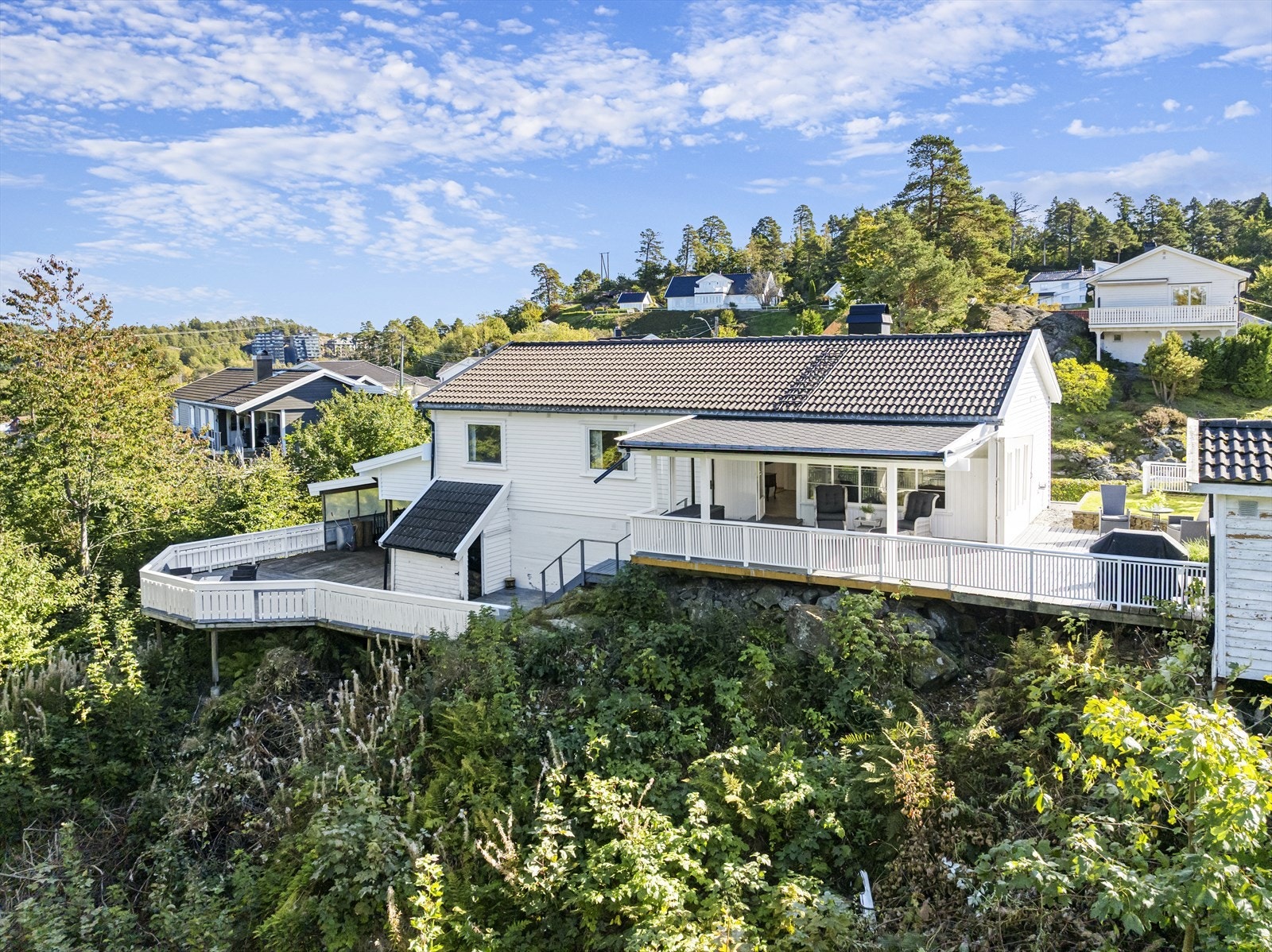 Mot vest er der stor terrasse, hvor man sitter skjermet i solen hele dagen. Her er også 2 praktiske hageboder. Videre har man direkte adgang til stor, vestvendt terrasse som vender mot friareal Galleribilde