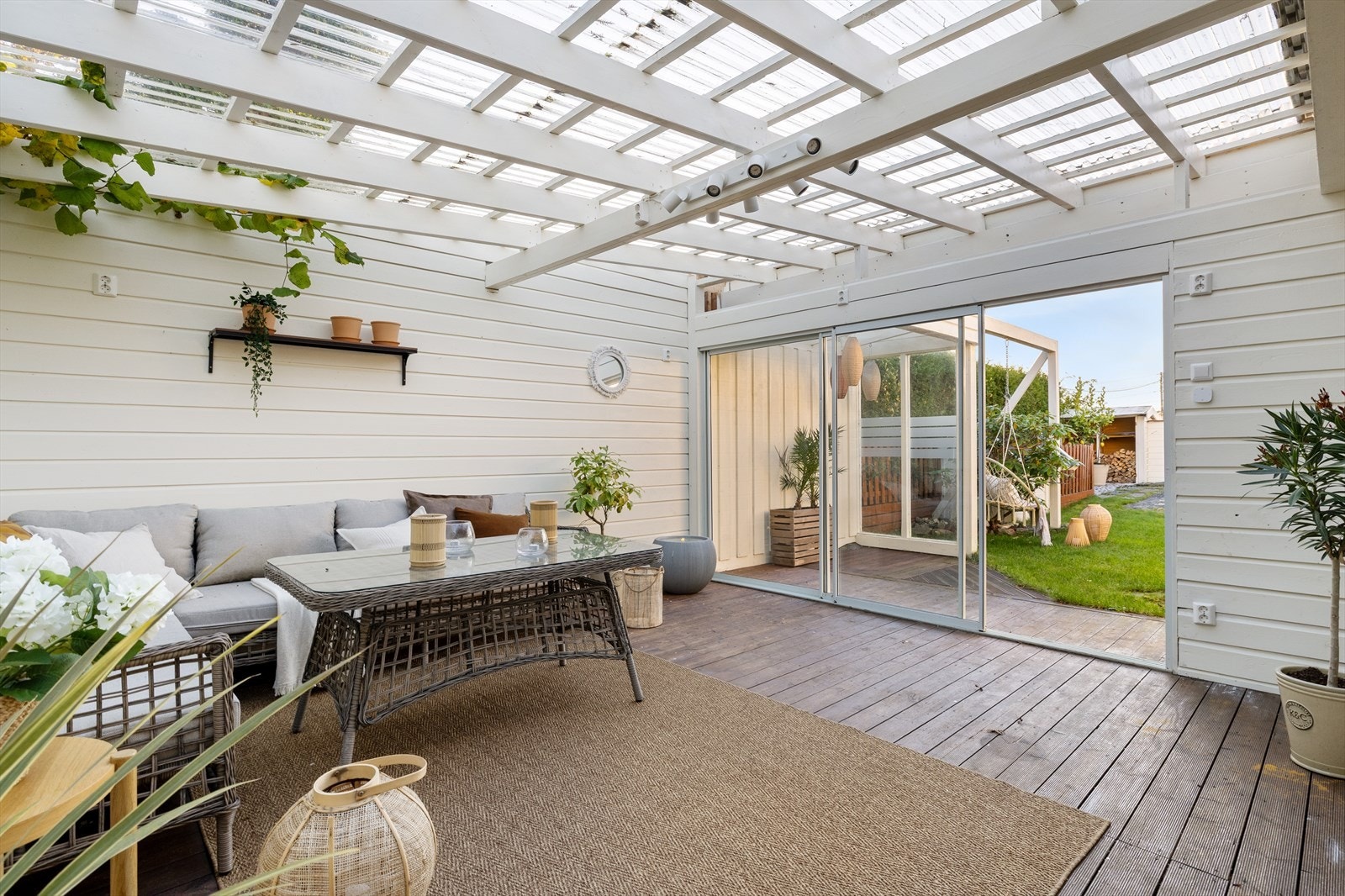 Tomten har gode soner både på oppsiden og nedsiden av huset - vinterhagen utenfor er oppført i senere tid, og har tilkomst til en større utebod som ikke er ferdigstilt. Galleribilde