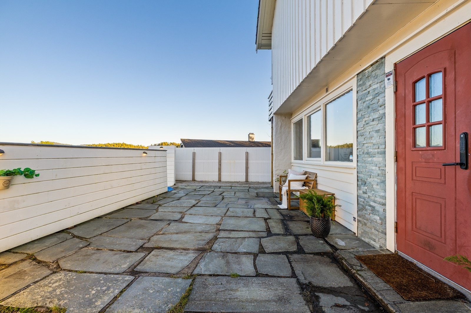 Fra inngangsparti har man også god tilkomst il nedsiden av tomten, med flere hyggelige soner. Galleribilde