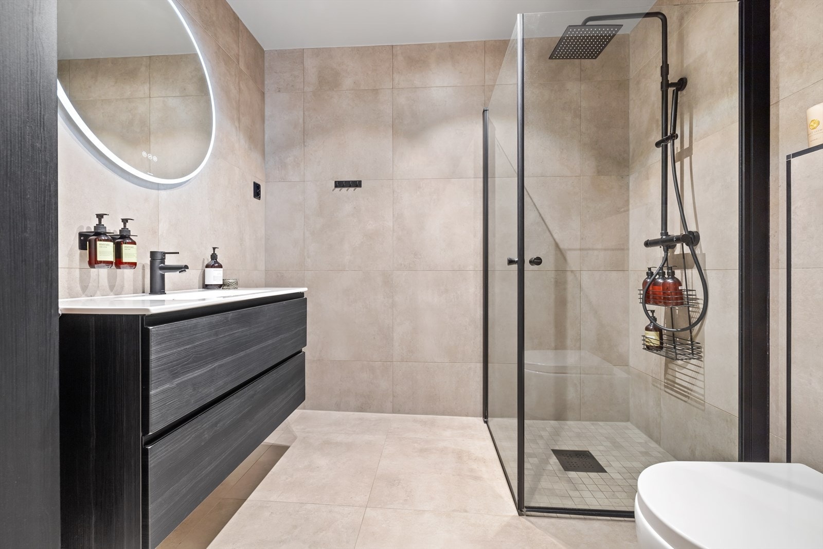 Delikat flislagt bad i tidløse fargetoner og gulvvarme. Galleribilde