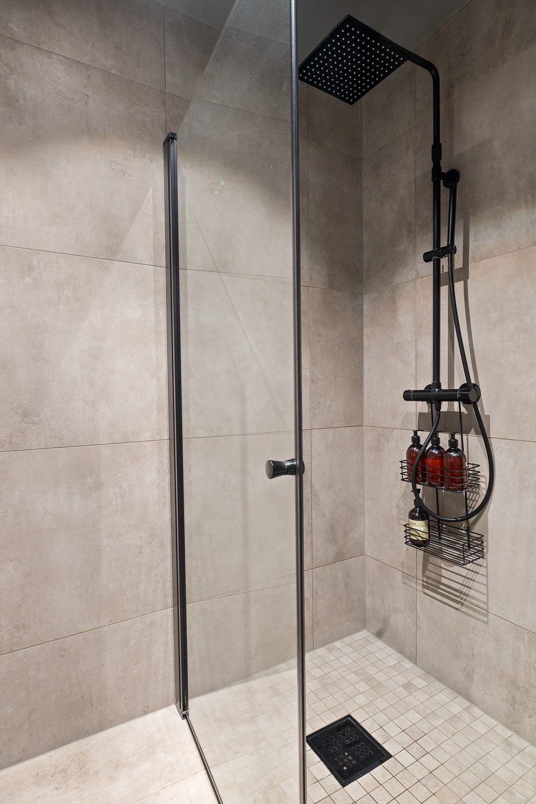 Badet er utstyrt med vegghengt toalett, servant med skuffer og dusjnisje med innfellbare glassdører. Galleribilde