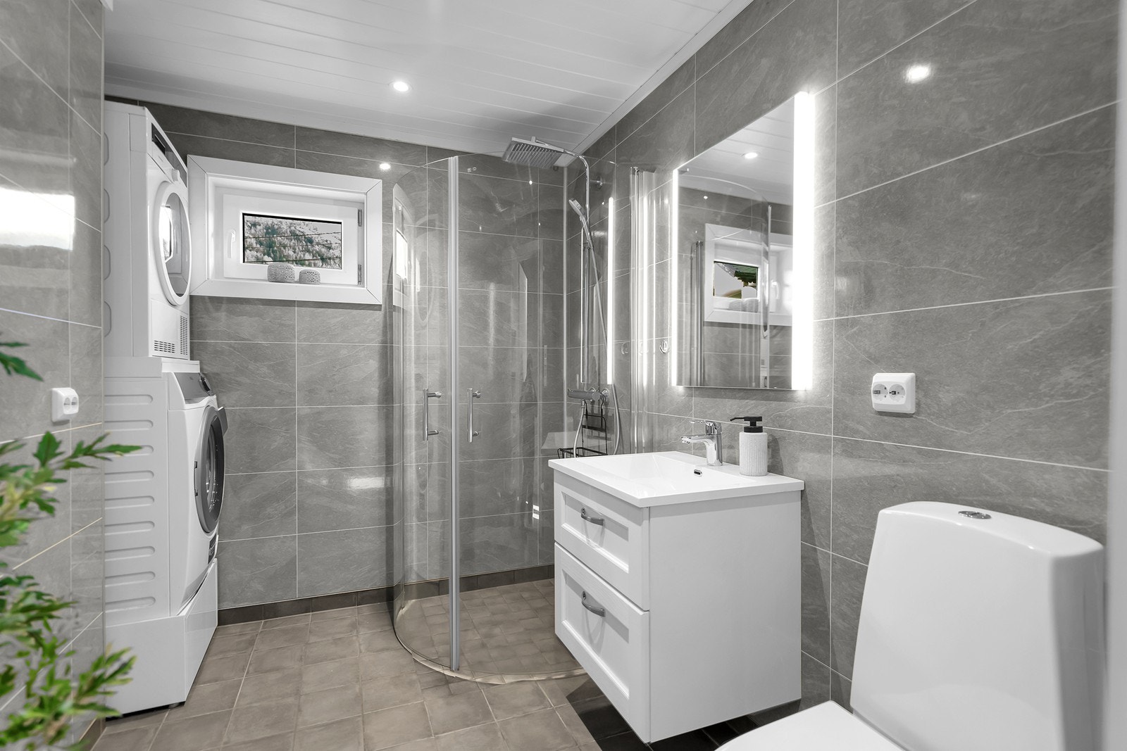 Pent flislagt bad med opplegg for vaskemaskin Galleribilde