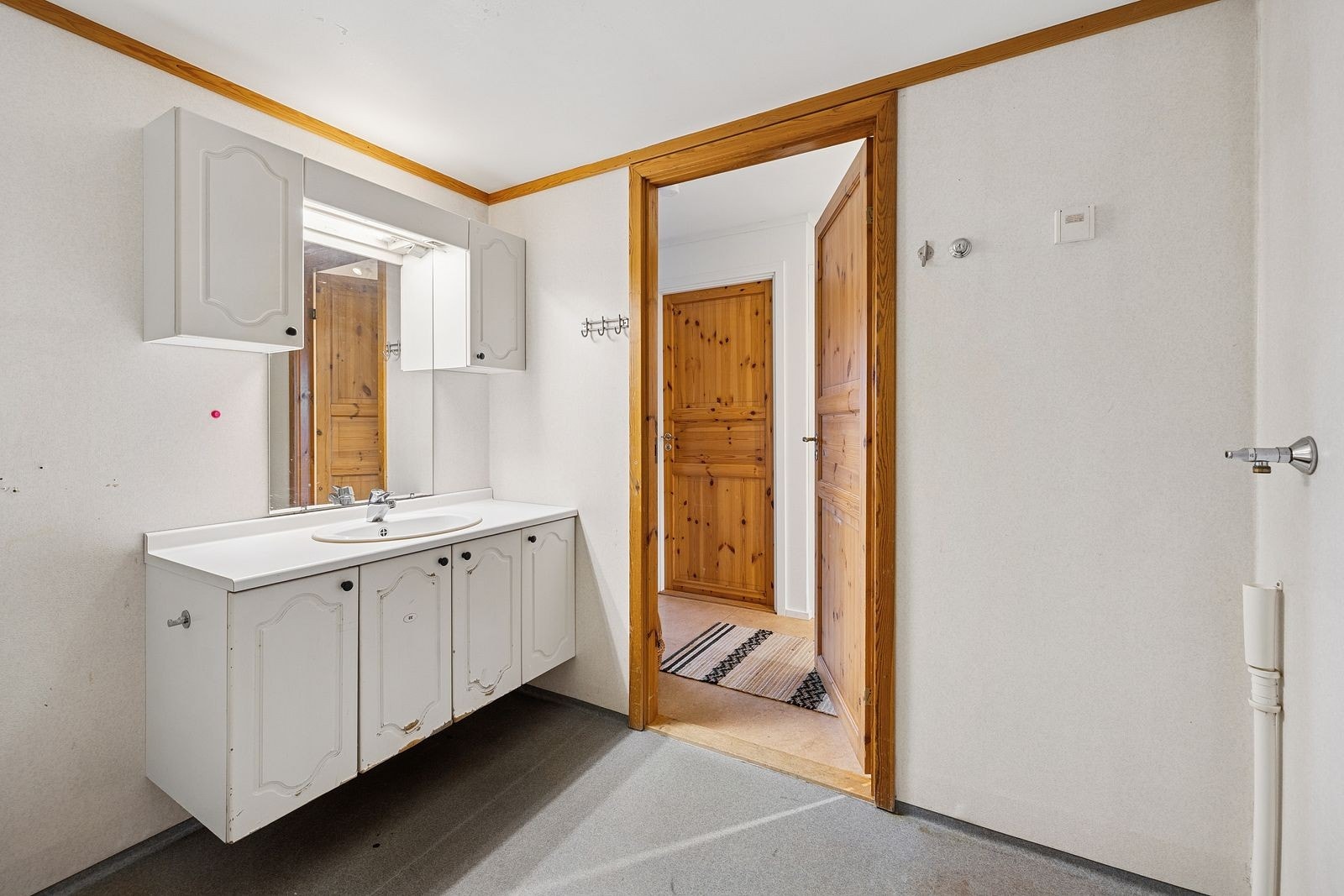 Badet har vinylbelegg på gulvet med elektriske varmekabler. Veggene er kledd med våtromstapet/belegg, hvor det er registrert noe løsning nederst på en vegg mot sør. Galleribilde