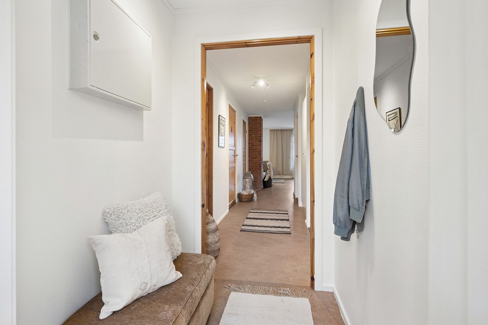 Fra vindfang ledes du videre innover i boligen via en gang med garderobeskap. Galleribilde