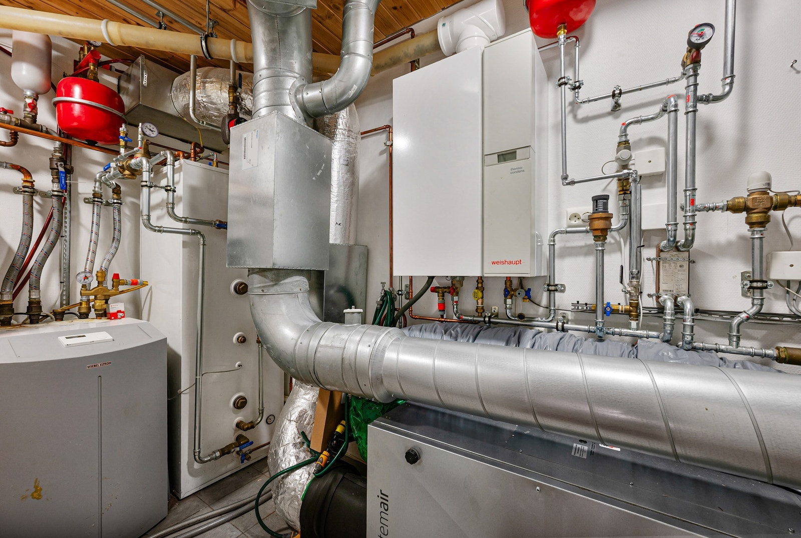 Teknisk rom med balansert ventilasjon med varmegjenvinning, bergvarmepumpe med vannbåren oppvarming. Galleribilde