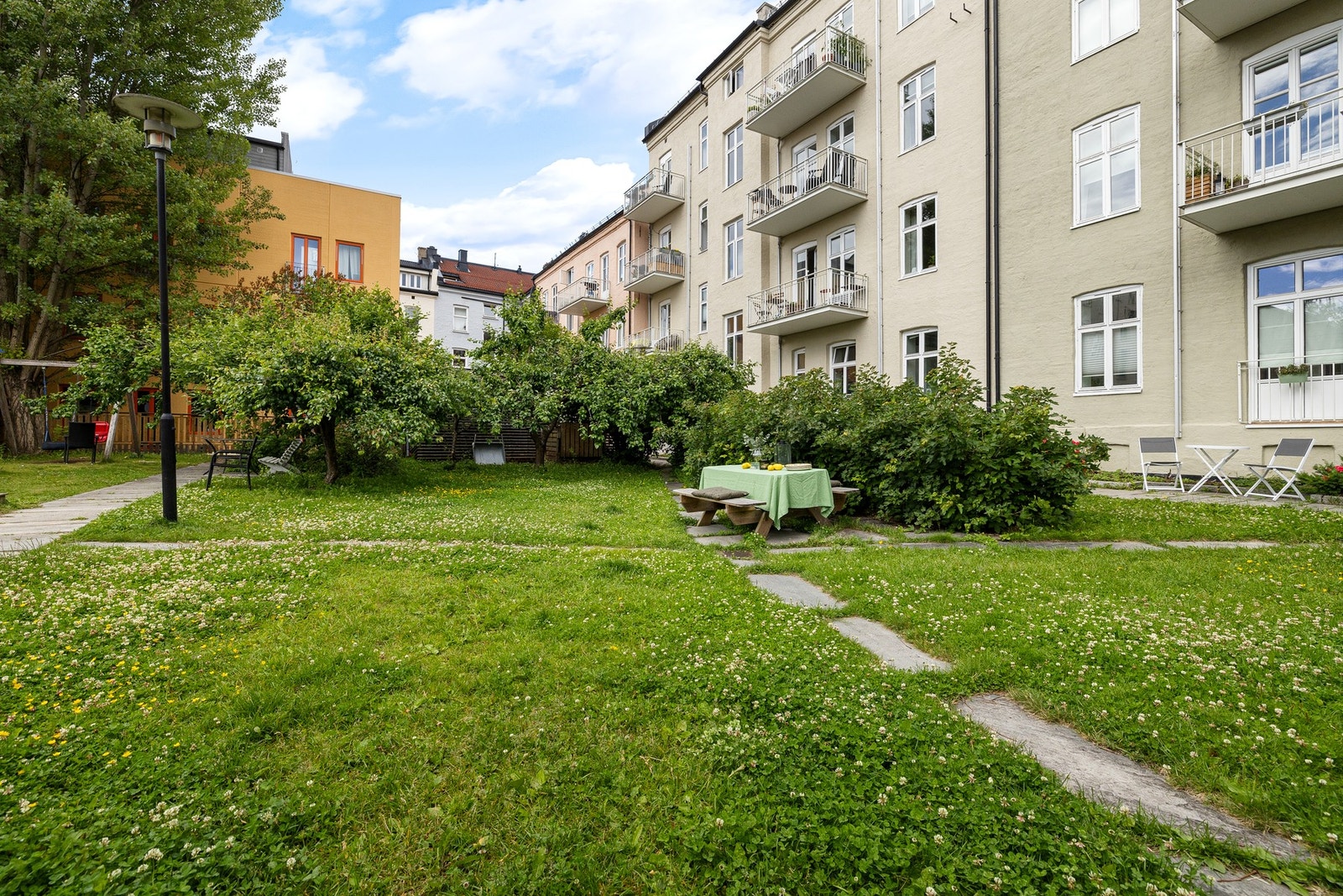 Felles gårdsrom, pent opparbeidet med gressplen, sittegrupper og gangstier. Galleribilde