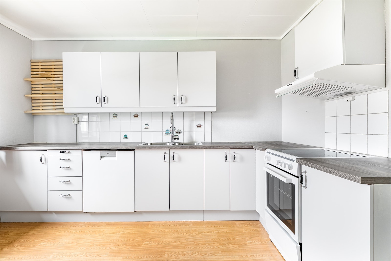 Kjøkkeninnredningen er fra leilighetens byggeår, men funksjonell og nylig oppgradert med blant annet nye benkeplater og nytt armatur. Galleribilde