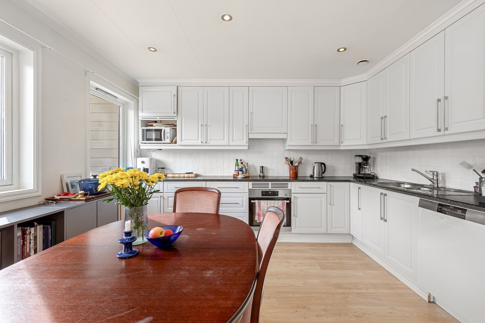 Flott kjøkken med innreiing i lys profil med benkeplate i laminat. Galleribilde