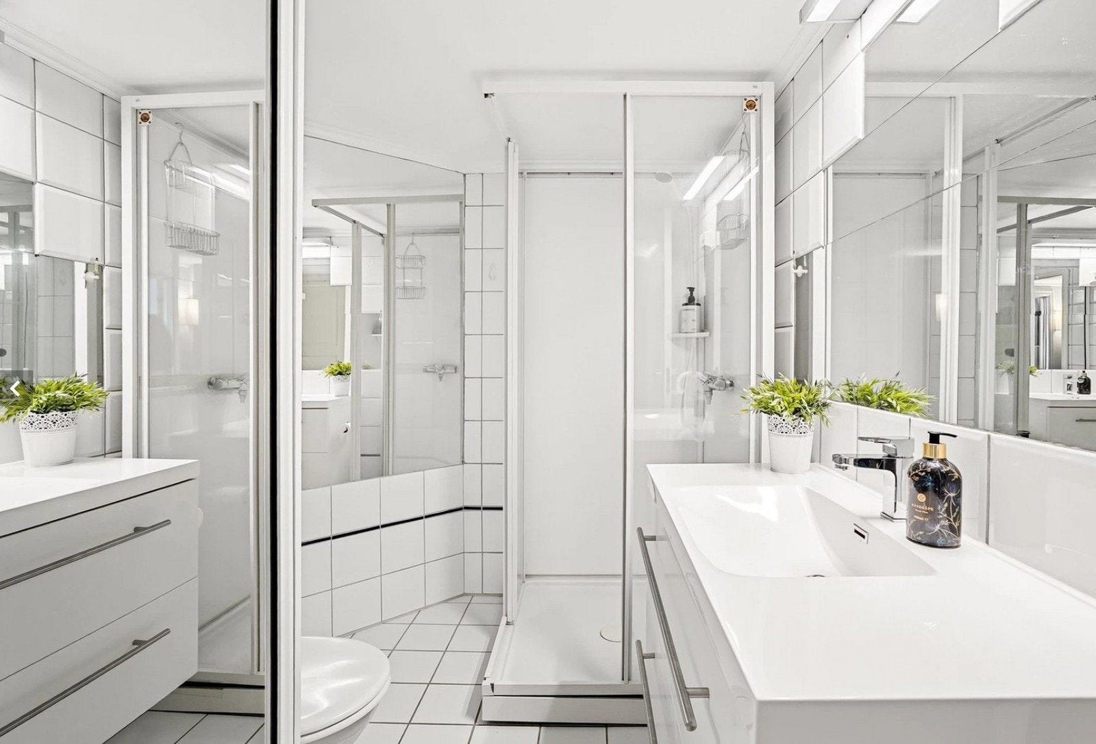 Bad med praktiske løsninger. Vaskemaskin og tørketrommel i skyvedørsgarderobe. Galleribilde