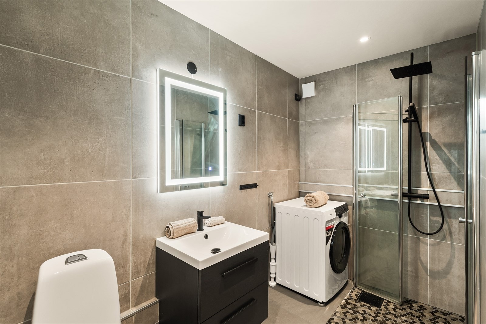 Badet har keramiske fliser på gulv og vegger, samt malt platekledning og innfelte spotlights i himlingen Galleribilde