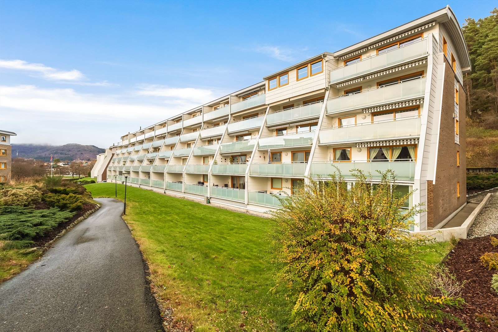 Tomten er felles for borettslaget og er flott opparbeidet med asfalt på veier, gangstier og parkeringsplasser samt flotte natursteinsmurer og beplantninger Galleribilde