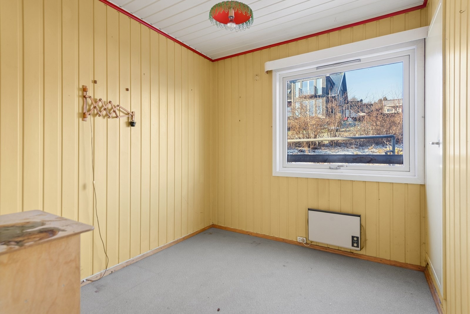 Panelvegger preger rommet, med vindu som gir naturlig lys. Galleribilde