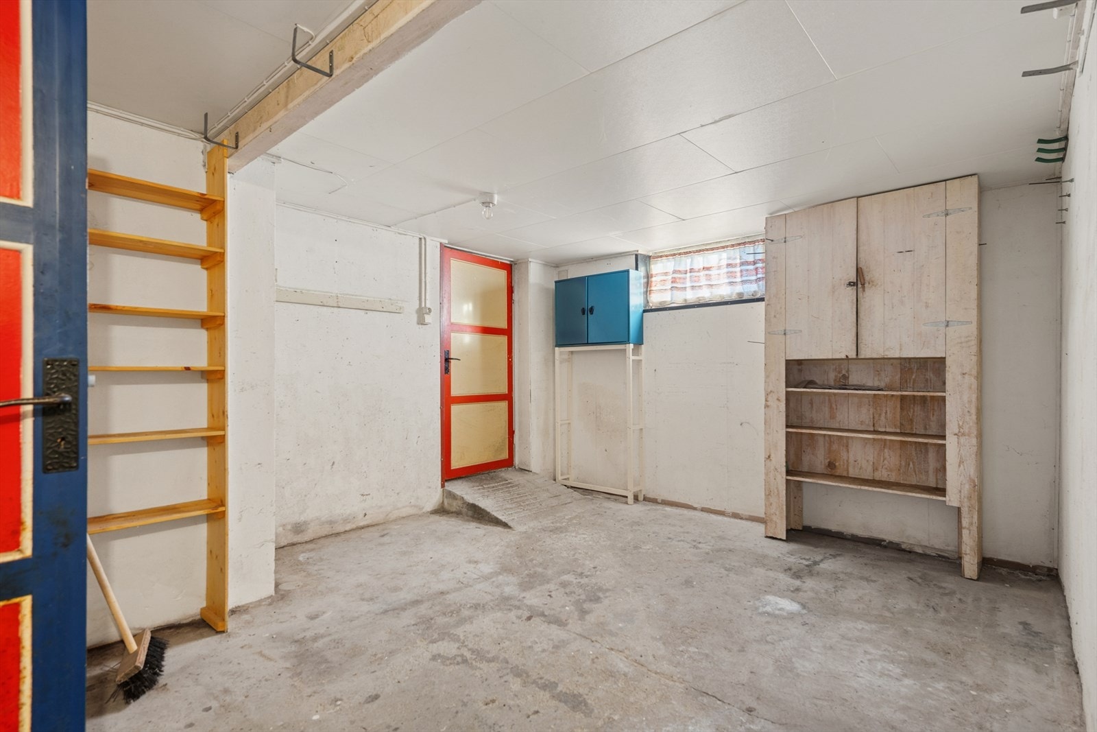 Betongvegger og enkelt hyllesystem gir rommet en praktisk lagringsløsning. Galleribilde