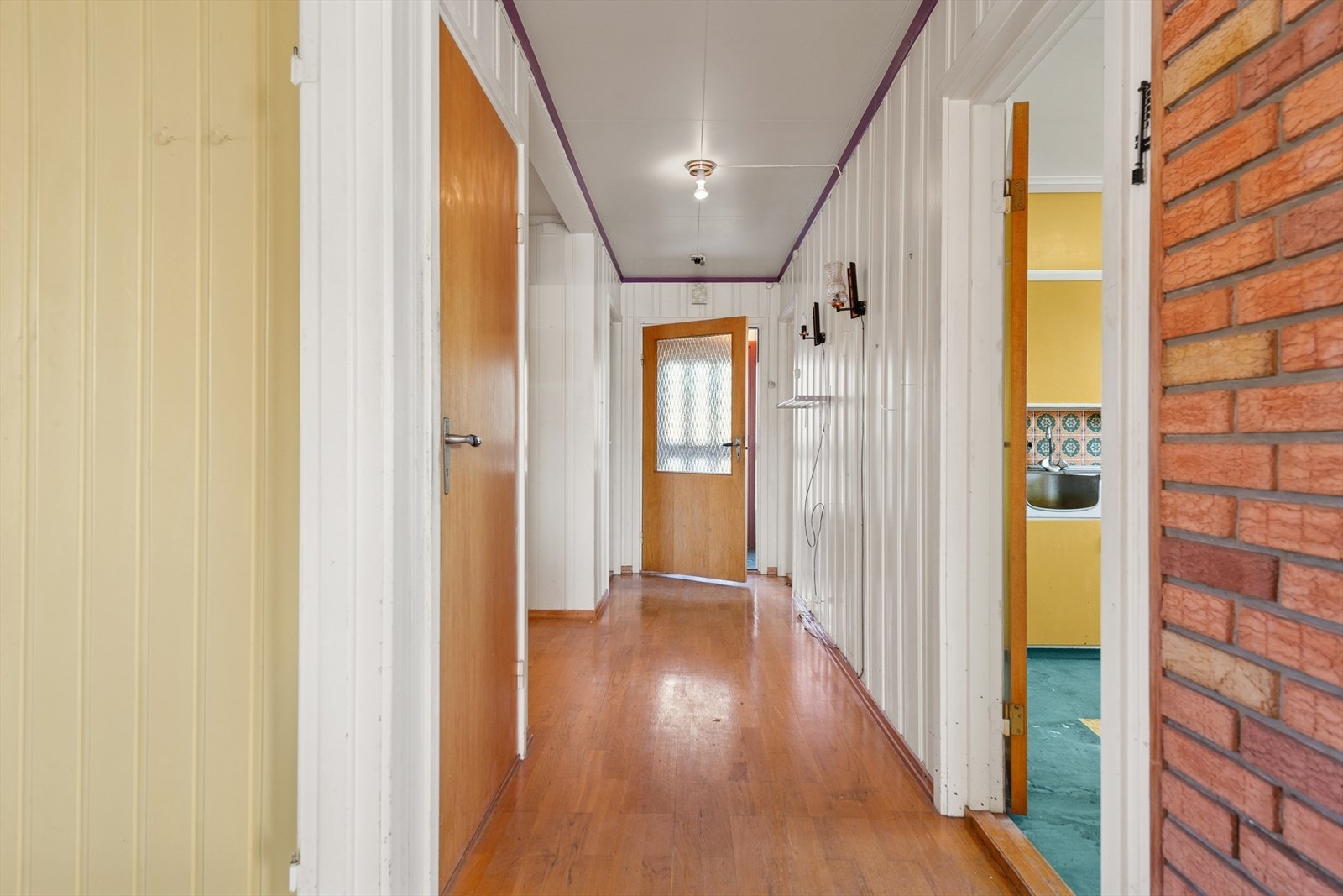 Lys innvendig entré med adgang til kjøkken og stue, samt formpressede dører med glassfelt. Galleribilde