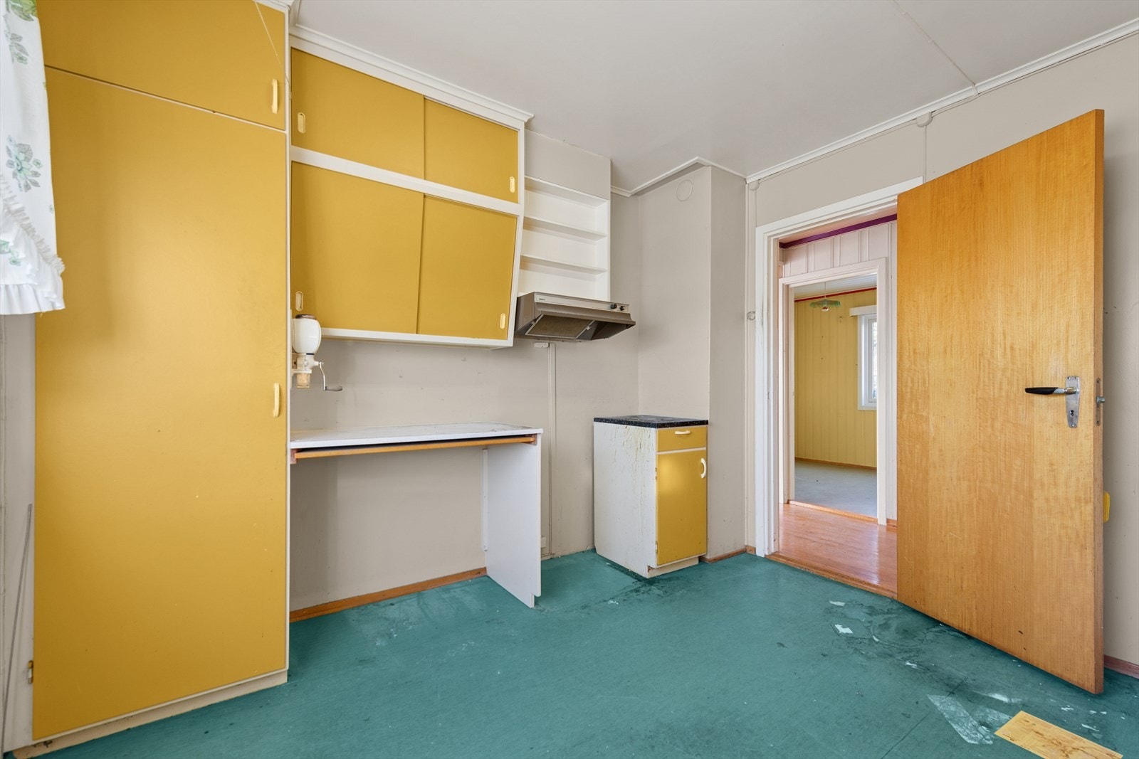 Kjøkkenet er av eldre dato med innredning i tre og laminert benkeplate med dobbel kjøkkenkum. Galleribilde