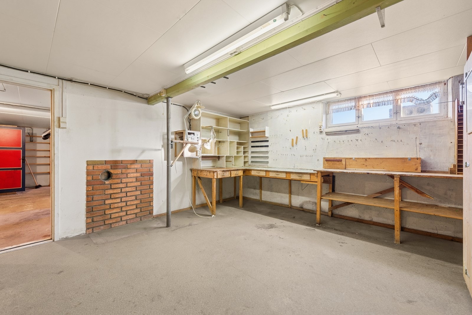 Verkstedrom med arbeidsbenker og murvegg gir rommet et funksjonelt preg. Galleribilde