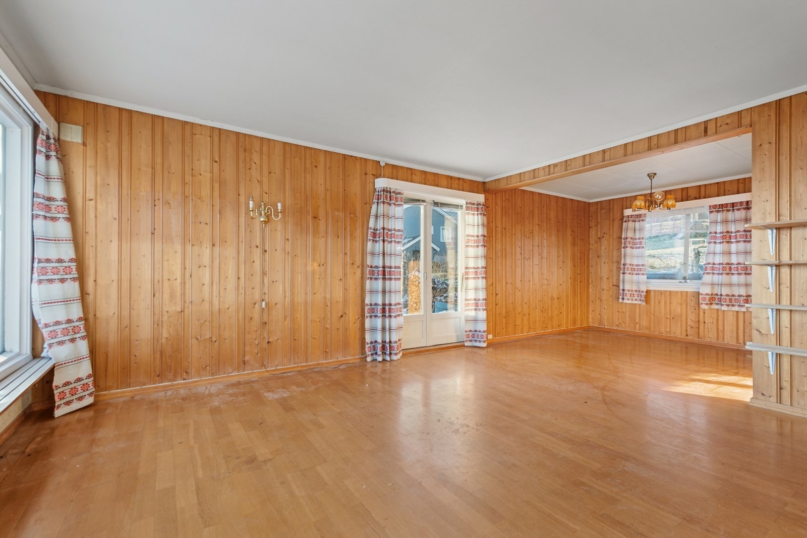 Fra stuen er det utgang til en stor og solrik hage med beplantning Galleribilde