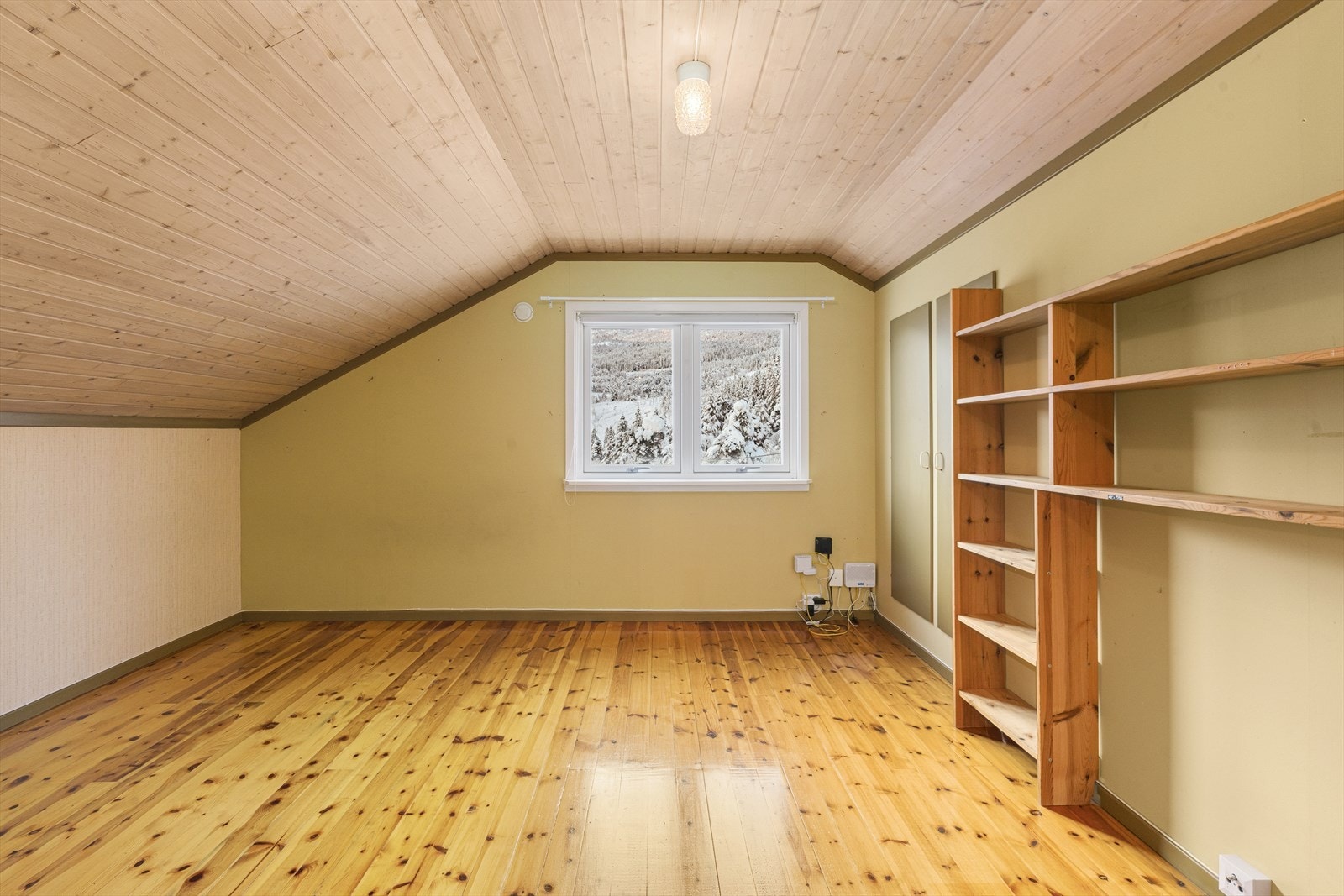 Utsikt mot snødekt landskap fra soverom på loft. Galleribilde