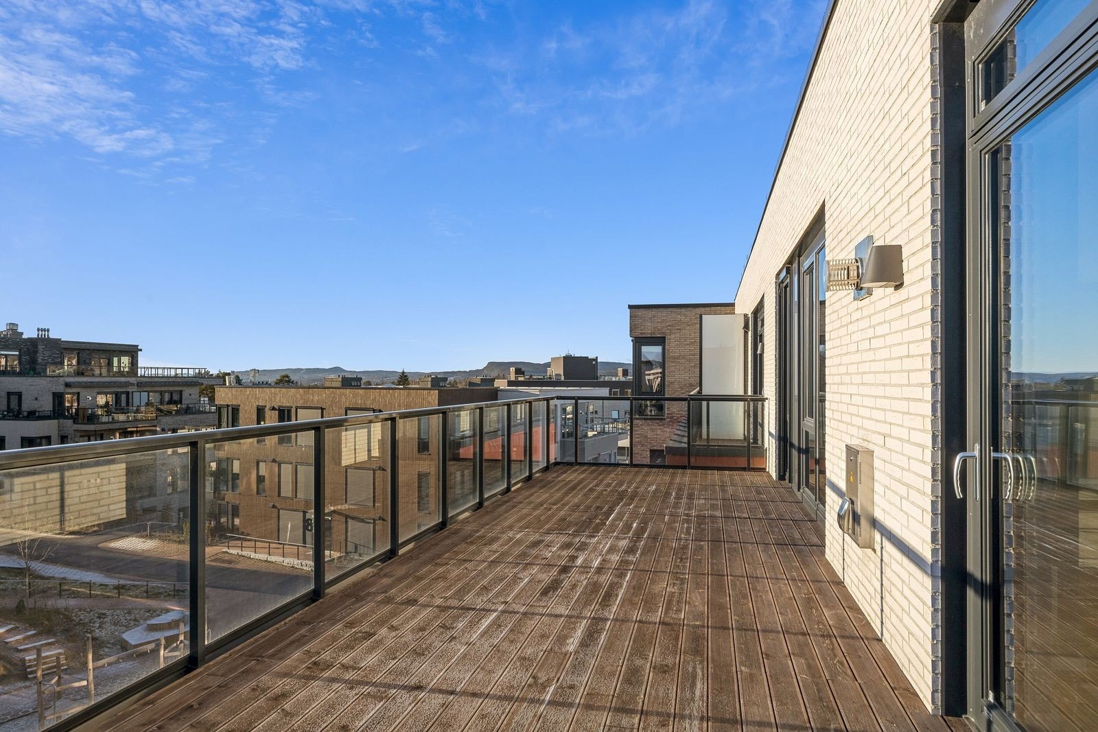 Stor, solrik terrasse med utgang fra stuene. Galleribilde
