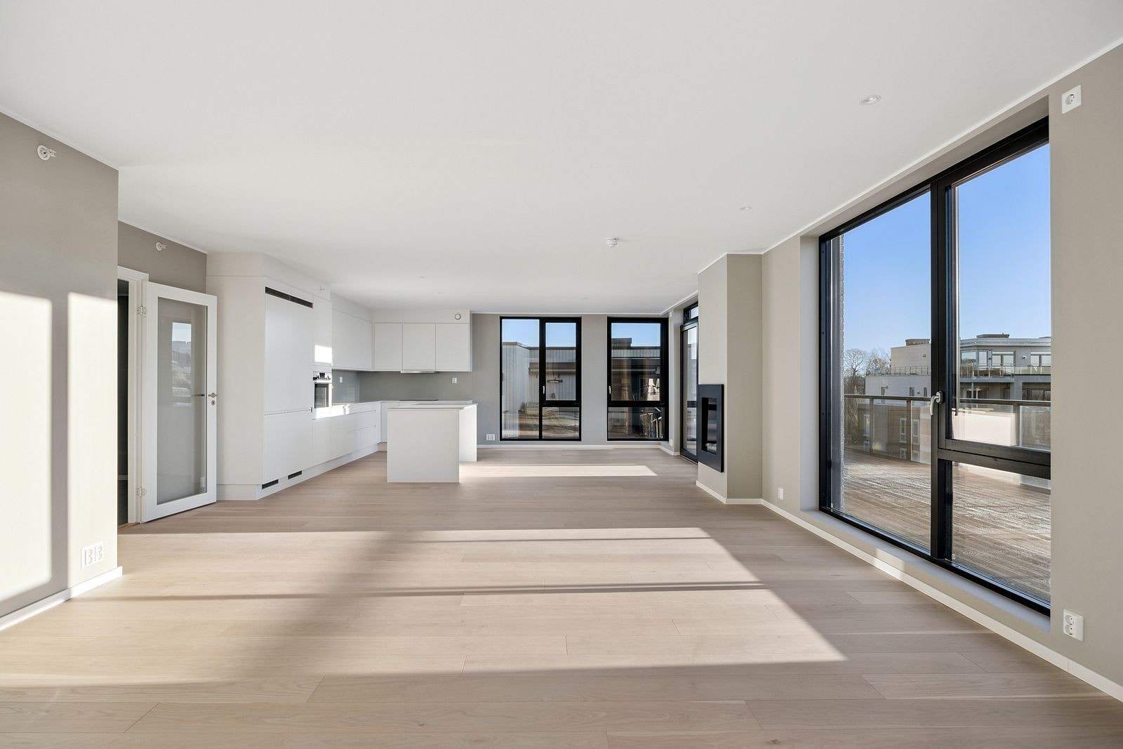 Stor, åpen stue/kjøkken løsning med gasspeis og utgang til solrik terrasse. Galleribilde