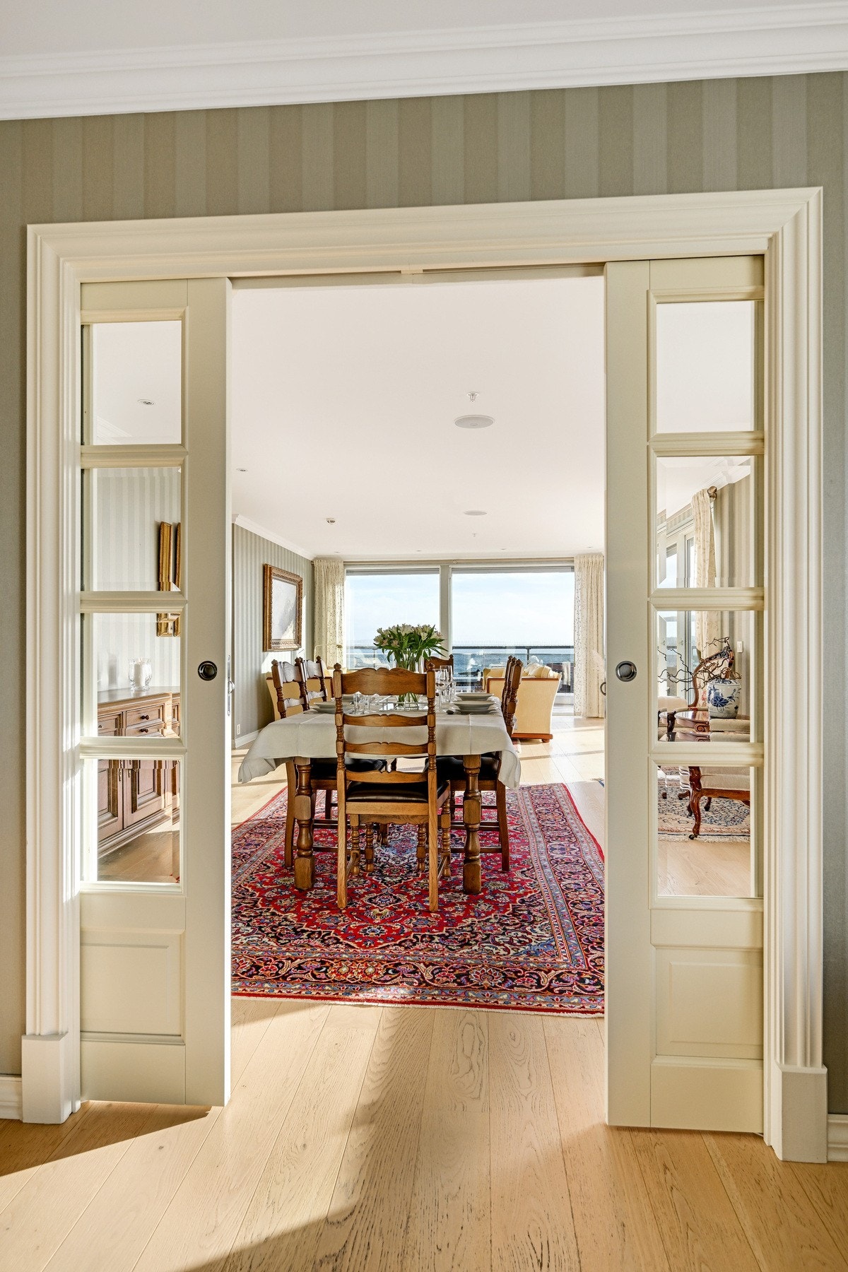 De to stuene er adskilt med dobbel skyvedør i glass Galleribilde