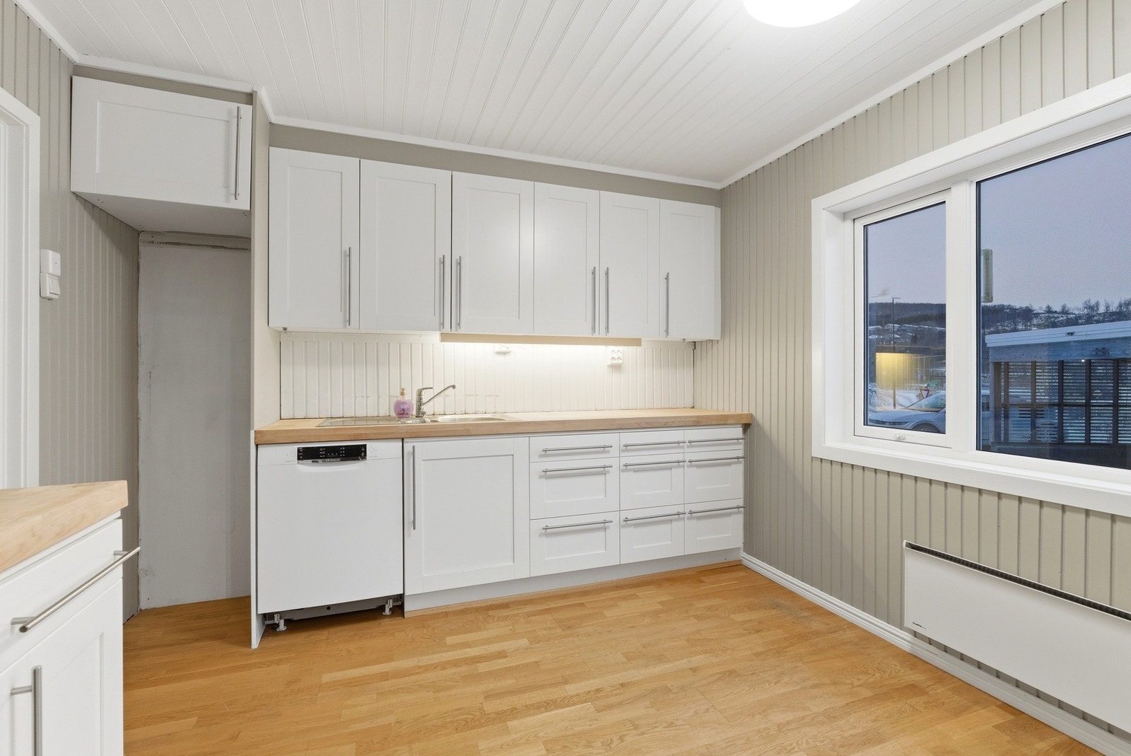 Lys kjøkkeninnredning med profilerte fronter og benkeplate av heltre. Galleribilde