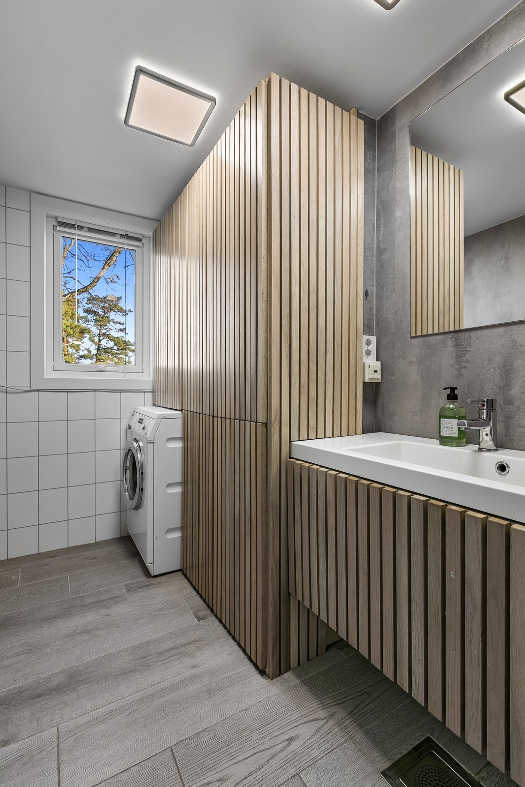 Badet fremstår delikat og inneholder dusjkabinett, håndvask og opplegg for vaskemaskin. Galleribilde